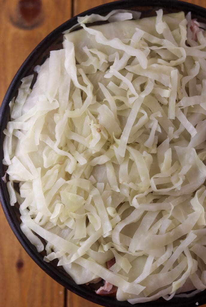 How to cover the second layer of stuffed cabbage rolls with sliced sour cabbage leaves before baking.
